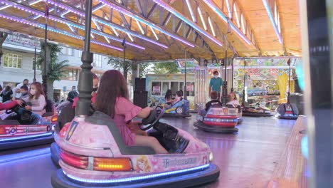 masked-children-have-fun-riding-bumper-cars-at-amusement-park
