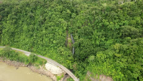 Catarata-al-frene-de-puente-y-rodeada-de-bosque,-vista-aÃ©rea-con-drone