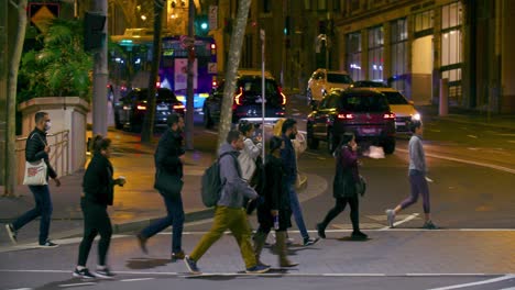 Vehicles-Stopped-As-People-Cross-The-Street-At-Night-In-Sydney,-NSW,-Australia
