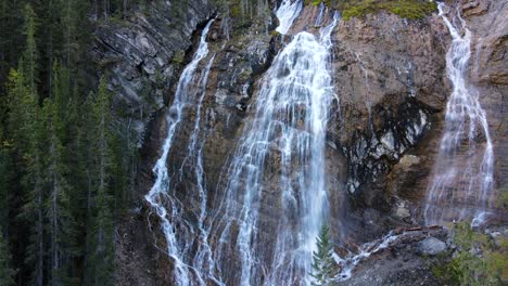 Drone-ascending-showing-a-set-of-waterfalls-in-a-natural-rocky-environment-in-Canada