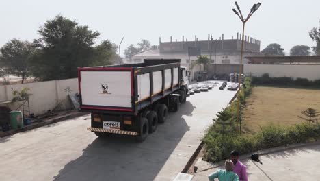 brand-new-load-dump-truck-parked-outside-the-manufacturing-production-factory-in-india-ready-to-hit-the-road-and-market