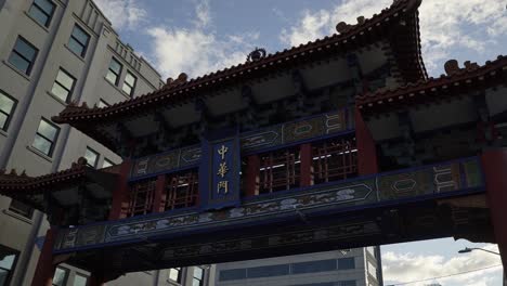 Beautiful-tilting-up-shot-of-the-famous-Seattle-Chinatown-International-District-entrance-gate-near-the-subway-and-restaurants-on-a-sunny-summer-day-in-Washington,-USA