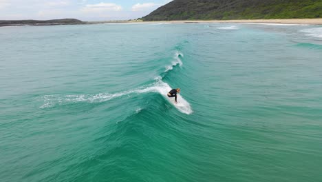 Surfer-catching-a-wave-at-the-popular-surf-destination,-Moonee-Beach-near-Coffs-Harbour,-New-South-Wales,-Australia
