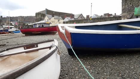 Fishing-boats-moored-on-low-tide-North-Wales-Welsh-pebble-beach-tourism-harbour