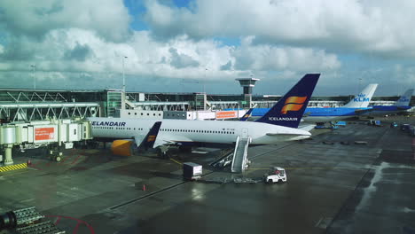 Statische-Ansicht-Von-Flugzeugen,-Gepäckwagen-Auf-Dem-Rollfeld-Des-Flughafens-Schiphol-Amsterdam