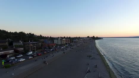 Sweeping-aerial-shot-of-Alki-Beach-in-West-Seattle-during-a-summer-sunset