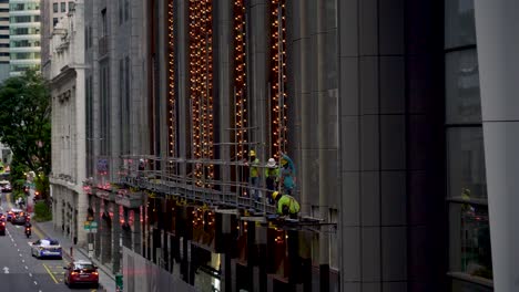 Workers-on-facade-of-building-downtown-CBD-Singapore-on-a-late-afternoon
