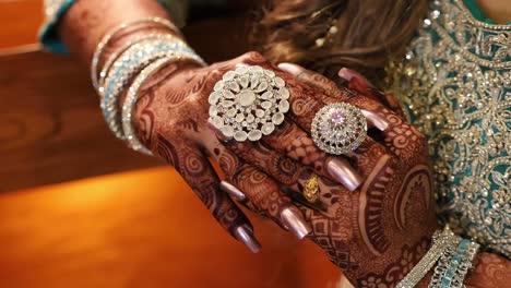 Close-Up-Of-Asian-Brides-Fingers-Clasped-And-Covered-In-Beautiful-Mehndi-Design
