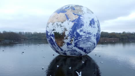 Luke-Jarram-floating-earth-art-exhibit-aerial-view-Pennington-flash-lake-nature-park-low-shot-orbit-right