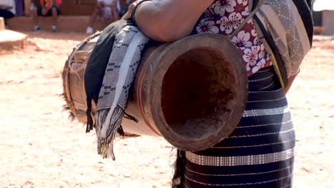 Women-wearing-traditional-Timorese-tais-clothing-with-a-homemade-drum-musical-instrument,-closeup-of-traditional-clothing-and-drum