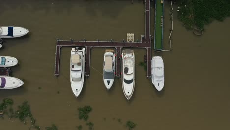 Top-down-drone-shot-over-river-marina-with-luxury-power-boats