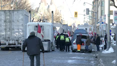 Polizei-überquert-Eine-Blockierte-Straße-Zwischen-Anwohnern-Und-Lastwagen,-Die-Gegen-Staatliche-Maßnahmen-Zu-Covid19-Streiken-–-Ottawa,-Ontario,-Kanada