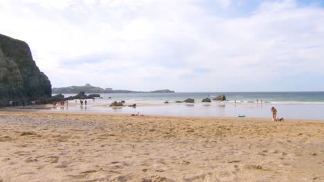 Zeitraffer-An-Einem-Strand-In-Cornwall-Mit-Menschen,-Die-Im-Sommer-Schwimmen-Und-Spazieren-Gehen