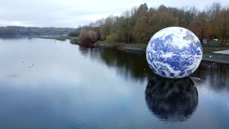 Luke-Jarram-floating-earth-art-exhibit-aerial-view-Pennington-flash-lake-nature-park-dolly-right
