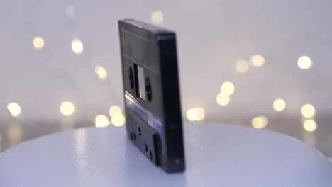 Black-plastic-TDK-retro-audio-tape-cassette-isolated-rotating-object