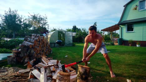 Slow-Motion-Shot-Of-A-Man-Forcefully-Breaking-A-Log-Using-An-Axe-During-Summer-In-Lithuania,-Europe