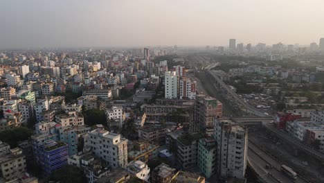 Aerial-View-Over-Dense-Asian-Metropolitan-Cityscape-Condominiums-With-Highway-Running-Past