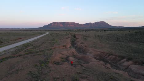 Solo-traveler-on-Endless-Outback-Scenery,-Wilpena-Pound-as-background