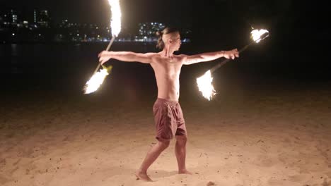 Badass-guy-fire-twirling-show-night-performance-slow-motion-sticks-beach