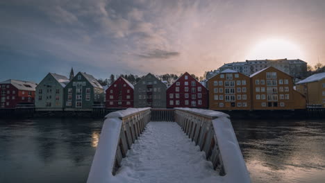 Old-Town-Bridge-Across-Nidelva-River-With-Walkway-Covered-In-Snow-At-Sunset-In-Trondheim,-Norway