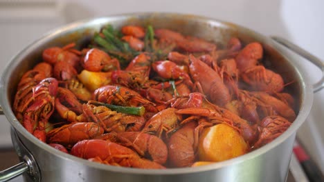 Fresh-seafood-red-Crayfish-shrimps-prawn-slowly-boiling-in-a-steel-pot,-warm-tasty-smoky-soup-recipe-cooked-in-professional-kitchen