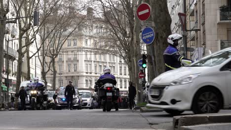 Police-divert-car-traffic-in-front-of-protesters-gathering-on-street-in-Lyon,-France
