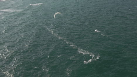 Luftaufnahme,-Während-Der-Kitesurfer-Wieder-In-Richtung-Strand-Abbiegt