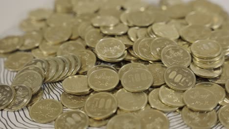 Colección-De-Monedas-De-500-Yenes,-Moneda-Japonesa-Dorada-En-La-Mesa