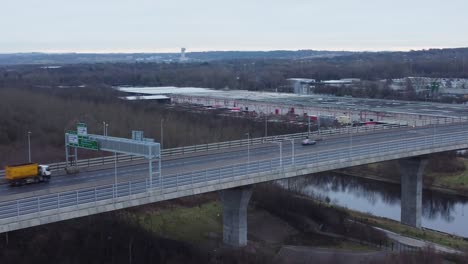 Mersey-gateway-toll-bridge-highway-traffic-driving-across-river-estuary-aerial-view-orbit-right