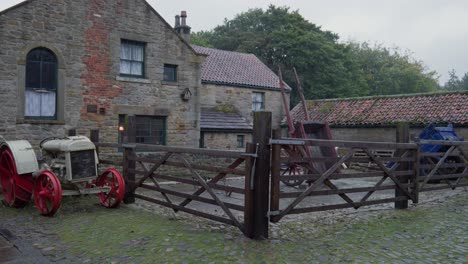 Farmhouse-enclosure-yard-Fordson-Model-F-tractor-red-metal-wheels