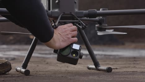a-man-fitting-a-thermal-camera-on-a-large-drone