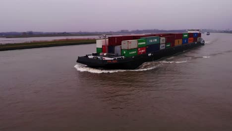 Aerial-View-Of-FPS-Rijn-Ship-Carrying-Containers-On-River-Noord-On-Cloudy-Afternoon