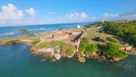 Fpv-drone-flight-over-San-Felipe-Fortress-and-harbor-with-boats-in-Puerto-Plata-during-sunny-day