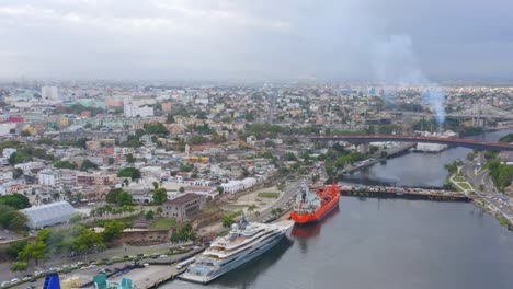 Luxuriöse-Yacht-Vor-Anker-Im-Hafen-Von-Don-Diego-Mit-Der-Stadt-Santo-Domingo-Im-Hintergrund,-Dominikanische-Republik