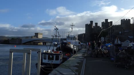 Fishermen-gathered-at-Conwy-harbour-fish-market-castle-town-preparing-for-morning-voyage