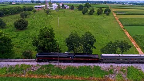 Eine-Parallele-Luftaufnahme-Eines-Antiken-Dampf-Personenzuges,-Der-Schwarzen-Rauch-Durch-Das-Ackerland-Von-Pennsylvania-Bläst