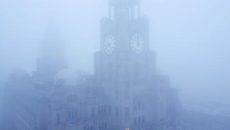 Dense-fog-cover-aerial-view-Liverpool-Liver-building-in-thick-gloomy-weather-visibility-pull-away