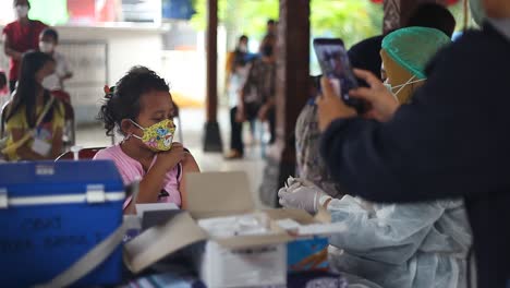 Yogyakarta,-Indonesia---Dec-20,-2021-:-an-elementary-school-girl-is-receiving-the-covid-19-vaccine