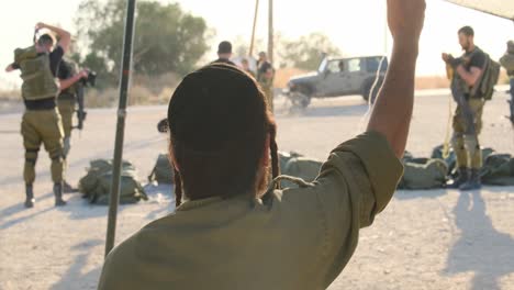 An-ultra-Orthodox-religious-soldier-with-a-cigarette-in-his-hand-dances-as-soldiers-prepare-for-fighting-with-equipment