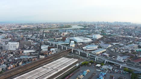 Japanische-Städtische-Luftaufnahme,-Bahnhof-Und-Autobahn-Mit-Stadt-Im-Hintergrund