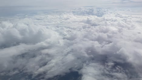 View-from-the-window-of-a-plane-over-fluffy-clouds-in-the-sky