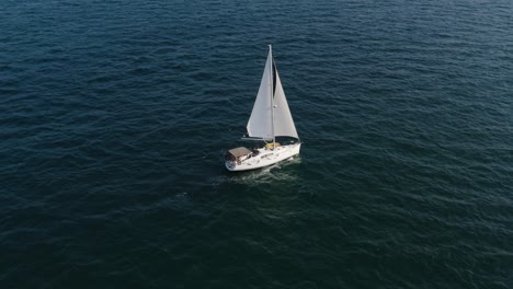 Ein-Luxuriöses-Segelboot-Mit-Zwei-Weißen-Segeln-Segelt-Ruhig-Im-Wind-über-Das-Ruhige,-Klare,-Plätschernde-Wasser-Des-Mittelmeers-In-Israel