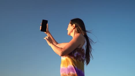 Middle-aged-Woman-With-Mobile-Phone-Having-Network-Issues-In-Blue-Sky-Background
