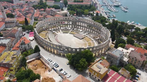 Aerial-rotating-shot-view-over-Roman-Arena-in-Pula,-Istria,-Croatia-which-is-a-Unesco-World-Heritage-site-on-the-seside-on-a-bright-sunny-day