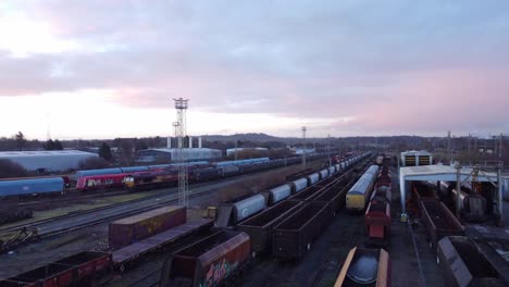 Aerial-view-over-long-train-yard-tracks-and-freight-shipping-tanker-railway-lines-forward-rising-shot