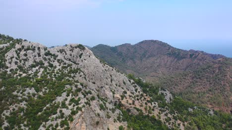 Malerische-Luftaufnahme-über-Die-Gipfel-Der-Rauen-Taurusgebirgslandschaft-Entlang-Der-Küste-Von-Antalya,-Türkei,-An-Einem-Sonnigen-Sommertag