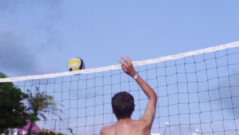 Volleyball-Wird-Von-Einem-Kaukasischen-Mann-über-Das-Netz-Geschlagen,-Von-Hinten-In-Zeitlupe-Gefilmt
