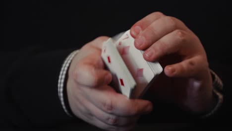 Close-up-of-a-pair-of-hands-and-a-deck-of-playing-cards-showing-off-with-tricks,-flourish-and-spread-in-4K