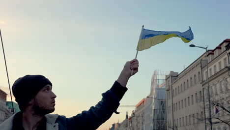 Man-waving-Ukrainian-flag-at-protest-against-war,-Prague,-slow-motion
