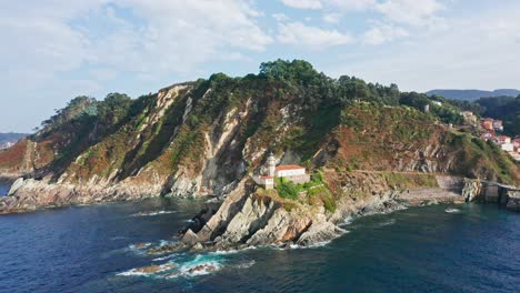 Aerial-Drone-Top-Notch-fly-above-Cudillero-cliff-lighthouse-in-Asturias,-blue-sea-in-north-Spain